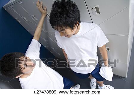 Teenage boys in gym clothes smiling and standing in locker room View Large Photo Image Stock Photo - Teenage boys in gym clothes smiling and standing in locker room. Fotosearch