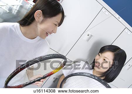 Teenage girls in gym clothes holding tennis rackets in locker room View Large Photo Image Stock Photo - Teenage girls in gym clothes holding tennis rackets in locker room. Fotosearch