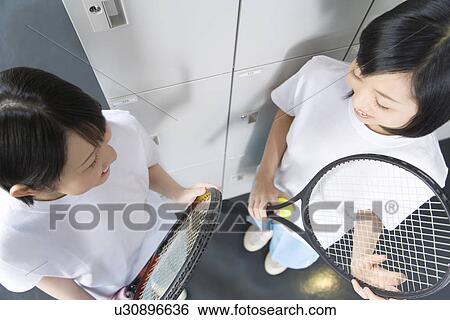 Teenage girls in gym clothes holding tennis ball and rackets in locker room View Large Photo Image Stock Photograph - Teenage girls in gym clothes holding tennis ball and rackets in locker room. Fotosearch