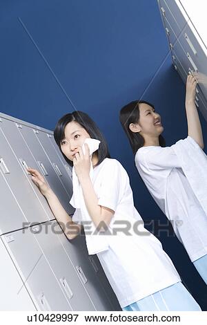 Teenage girls in gym clothes in locker room, one wiping face with towel View Large Photo Image Stock Photo - Teenage girls in gym clothes in locker room, one wiping face with towel. Fotosearch