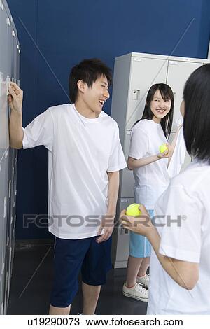 Three teenagers in gym clothes smiling and talking in locker room, girls holding tennis balls View Large Photo Image Stock Image - Three teenagers in gym clothes smiling and talking in locker room, girls holding tennis balls. Fotosearch