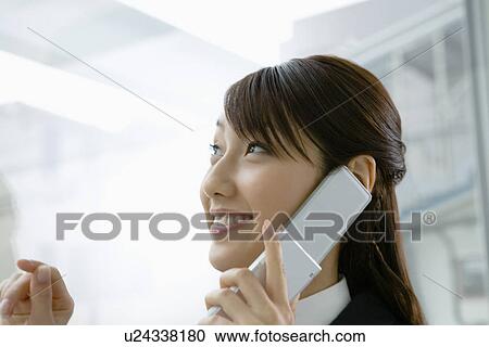 Stock Image - Businesswoman on a Mobile Phone, Head and Shoulder, Side View. Fotosearch