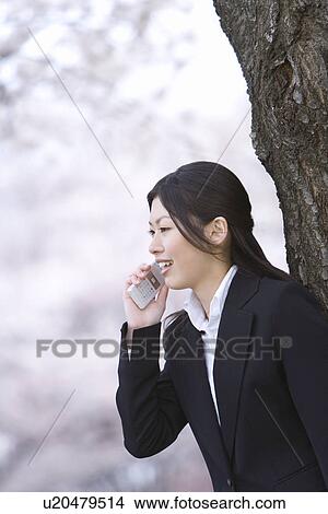 Businesswoman Talking on Mobile Phone, Waist Up, Side View, Differential Focus View Large Photo Image Picture - Businesswoman Talking on Mobile Phone, Waist Up, Side View, Differential Focus. Fotosearch