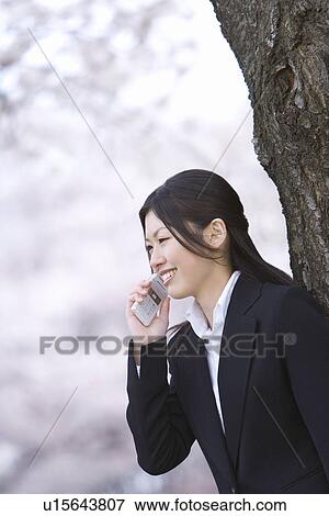 Stock Photo - Businesswoman Talking on Mobile Phone, Waist Up, Side View, Differential Focus. Fotosearch