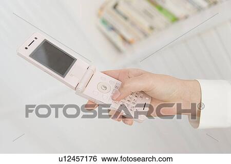 Girl holding a mobile phone, side view, close up View Large Photo Image Stock Photograph - Girl holding a mobile phone, side view, close up. Fotosearch