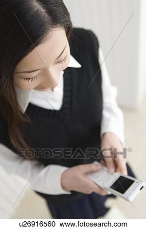 Girl using mobile phone, high angle view View Large Photo Image Stock Image - Girl using mobile phone, high angle view. Fotosearch
