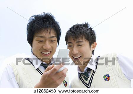 Stock Photo - High School Boys Looking at Mobile Phone Together. Fotosearch