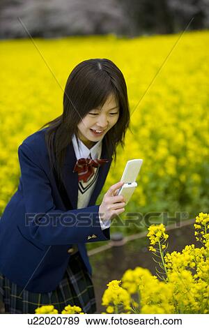 Stock Photo - High School Student Taking Picture with Mobile Phone, Differential Focus. Fotosearch