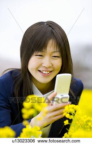 Stock Photograph - High School Student Taking Picture with Mobile Phone, Differential Focus. Fotosearch