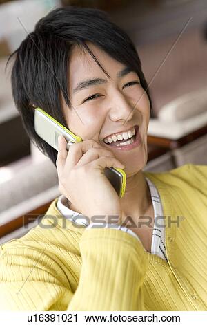 Young man smiling and using mobile phone in Japanese inn, front view, Japan View Large Photo Image Stock Image - Young man smiling and using mobile phone in Japanese inn, front view, Japan. Fotosearch