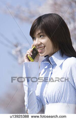 Stock Photo - Young Woman Talking on Mobile Phone, Differential Focus, Side View. Fotosearch