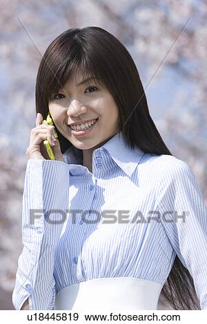 Young Woman Talking on Mobile Phone, Differential Focus, Front View View Large Photo Image Stock Photo - Young Woman Talking on Mobile Phone, Differential Focus, Front View . Fotosearch
