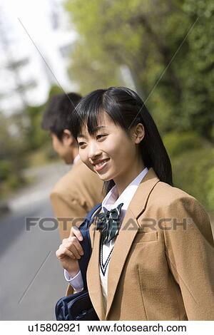 Stock Image - High School Girl and Boy in the Background on Street. Fotosearch