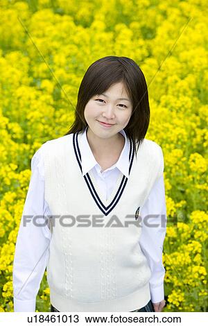 Stock Image - High School Girl In Rape Seed Blossom Field, Differential Focus. Fotosearch