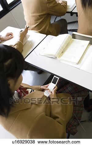 High School Girl Using Mobile Phone Secretly During Lecture View Large Photo Image Stock Photo - High School Girl Using Mobile Phone Secretly During Lecture. Fotosearch