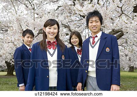 High School Student In Grass Field with Cherry Blossoms in the Background View Large Photo Image Picture - High School Student In Grass Field with Cherry Blossoms in the Background. Fotosearch