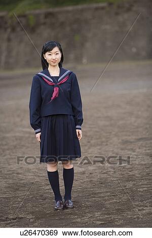 Stock Photo - Portrait of a teenage girl standing in schoolyard, smiling and looking at camera. Fotosearch