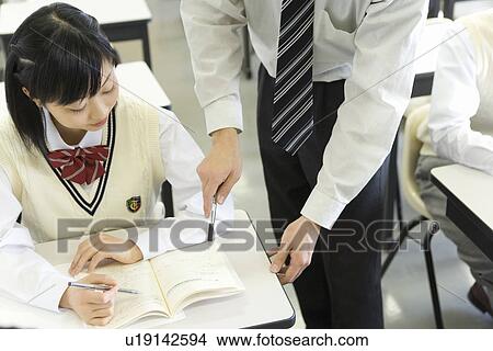 Picture - Teacher advising female student in class. Fotosearch
