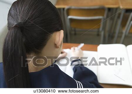 Stock Image - Teenage girl studying at desk. Fotosearch