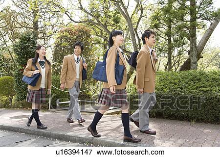 Stock Photo - Four high school students walking down the street, smiling. Fotosearch