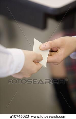 Stock Image - High school students exchanging memo during class. Fotosearch