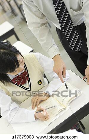 Teacher advising female student in class View Large Photo Image Stock Image - Teacher advising female student in class. Fotosearch