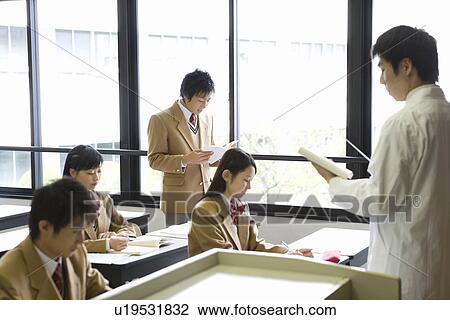 Stock Image - Teacher Let Student Read Textbook. Fotosearch