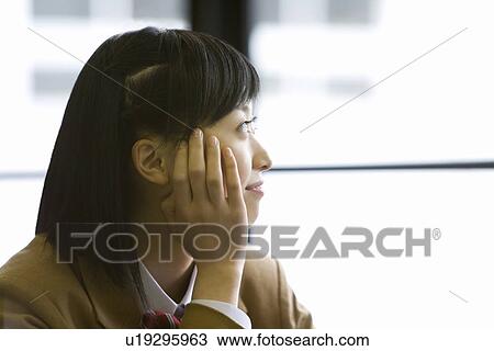 Teenage girl resting chin in hand, smiling and looking outside from the window View Large Photo Image Stock Image - Teenage girl resting chin in hand, smiling and looking outside from the window. Fotosearch