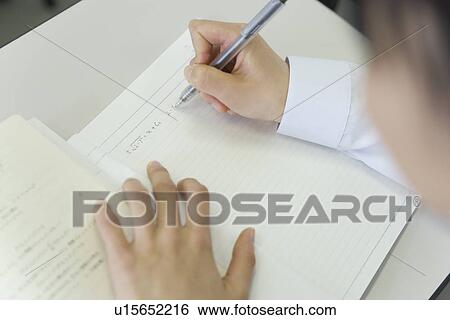 Stock Photograph - Teenage girl studying at desk in classroom. Fotosearch