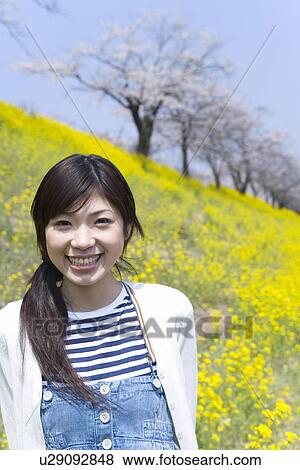 Portrait of a woman standing in rape field, smiling and looking at camera, front view, Japan View Large Photo Image Stock Photo - Portrait of a woman standing in rape field, smiling and looking at camera, front view, Japan. Fotosearch