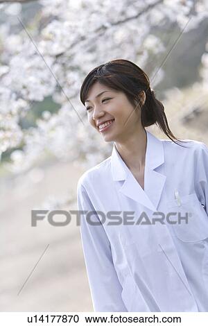 Woman in lab coat smiling and standing under the cherry tree, front view, Japan View Large Photo Image Stock Image - Woman in lab coat smiling and standing under the cherry tree, front view, Japan. Fotosearch