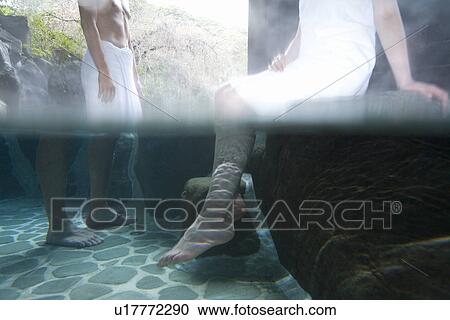Stock Image - Japanese couple in a hot tub, side view, Japan. Fotosearch