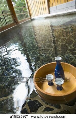 Sake bottle and cups in a wooden tub floating on Japanese common tub, hot spring, high angle view, Japan View Large Photo Image Stock Image - Sake bottle and cups in a wooden tub floating on Japanese common tub, hot spring, high angle view, Japan. Fotosearch