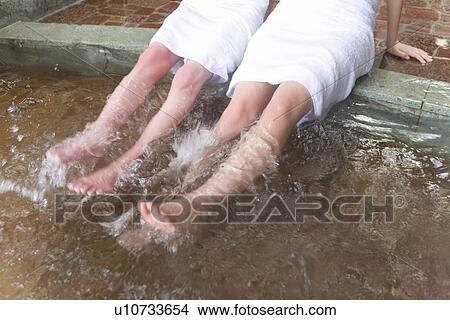 Picture - Two women soaking legs in hot tub, high angle view, blurred motion, Japan. Fotosearch