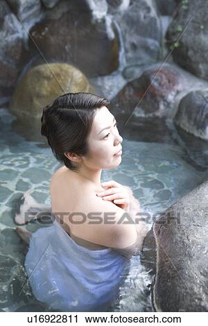 Stock Image - Woman in a hot tub, high angle view, Japan. Fotosearch