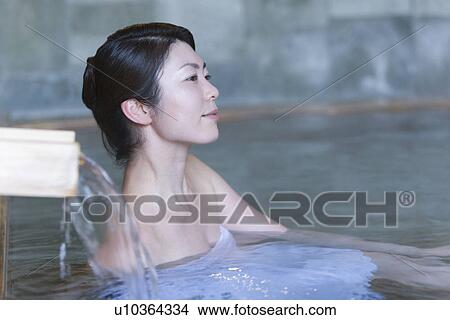 Picture - Woman in a hot tub, side view, Japan. Fotosearch