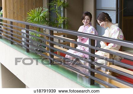 Stock Photo - Women in Yukata soaking legs in the footbath, side view, Japan. Fotosearch
