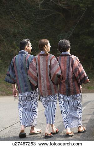 Stock Image - Mature Adult Couple and their Daughter in Yukata Walking, Rear View, Full Length. Fotosearch