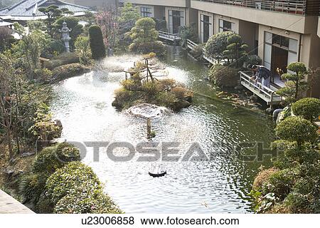 Stock Photo - Mature Adult Couple Looking at Carp from the Wooden Balcony, Side View, High Angle View, Full Length. Fotosearch