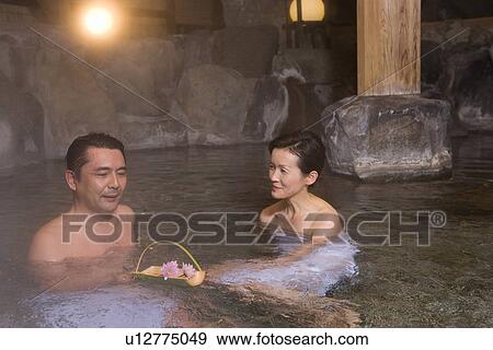Stock Photo - Mature Adult Couple Taking a Hot Spring Bath Together, Side View, Head and Shoulder. Fotosearch