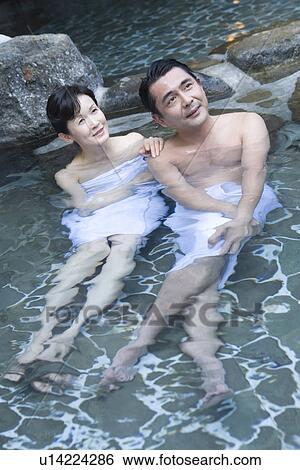 Stock Photograph - Mature Adult Couple Taking a Hot Spring Bath Together, Front View, Full Length, High Angle View. Fotosearch