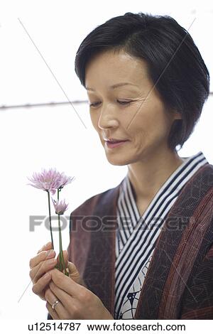 Stock Photo - Mature Adult Woman in Yukata Holding Flowers, Side View, Head and Shoulder. Fotosearch