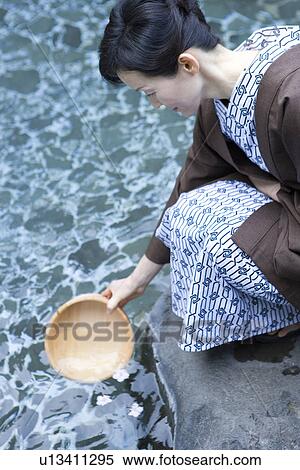 Mature Adult Woman Trying to Scoop Up Cherry Blossoms By a Wooden Pail, Side View, Three Quarter Length, High Angle View View Large Photo Image Stock Photography - Mature Adult Woman Trying to Scoop Up Cherry Blossoms By a Wooden Pail, Side View, Three Quarter Length, High Angle View. Fotosearch