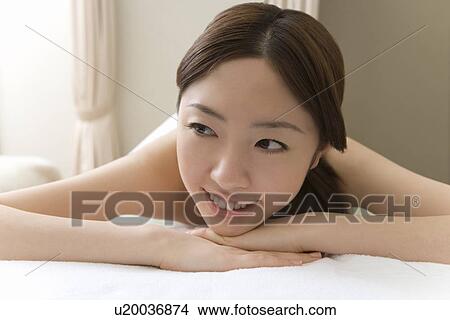 Woman lying on bed in beauty salon, smiling, front view, Japan View Large Photo Image Picture - Woman lying on bed in beauty salon, smiling, front view, Japan. Fotosearch