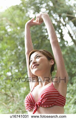 Woman stretching arms out in woods, in a bathing suit, low angle view, Japan View Large Photo Image Stock Image - Woman stretching arms out in woods, in a bathing suit, low angle view, Japan. Fotosearch