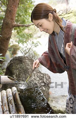 Young Adult Woman in Yukata Scooping Water with a Ladle, Side View, Three Quarter Length View Large Photo Image Stock Image - Young Adult Woman in Yukata Scooping Water with a Ladle, Side View, Three Quarter Length. Fotosearch