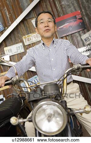 A Mature Adult Man on a Motorcycle, Front View, Low Angle View View Large Photo Image Stock Image - A Mature Adult Man on a Motorcycle, Front View, Low Angle View. Fotosearch