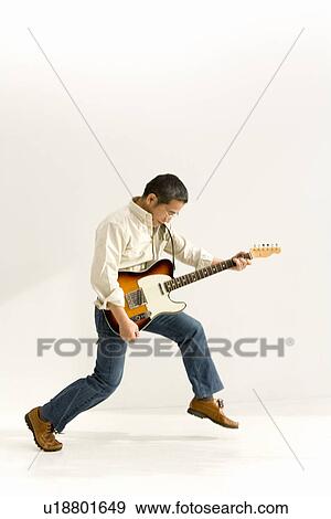 Stock Photo - A Mature Adult Man Playing a Guitar, Side View. Fotosearch