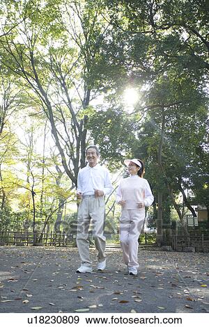 Stock Photo - A Senior Adult Couple Jogging Together, Low Angle View. Fotosearch