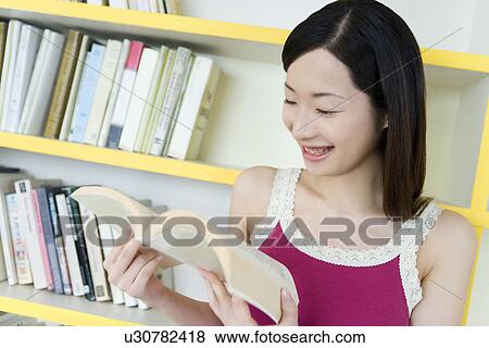 Portrait of a Young Woman Reading a Book, Smiling, Front View View Large Photo Image Stock Photo - Portrait of a Young Woman Reading a Book, Smiling, Front View. Fotosearch